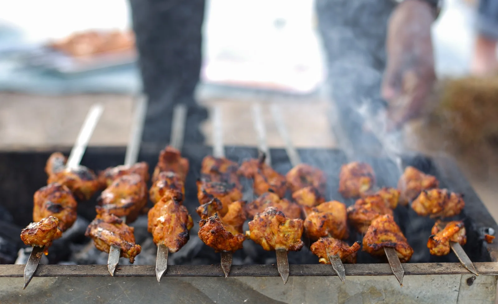 Chicken tikka kababs cooking over charcoal